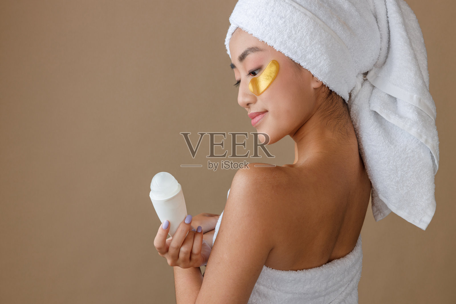 亚洲年轻女子，眼罩下戴着除臭剂照片摄影图片