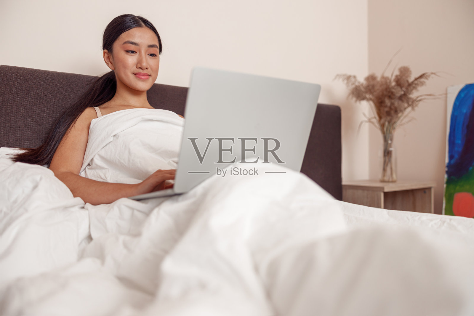 亚洲年轻女性在家里使用现代笔记本电脑照片摄影图片