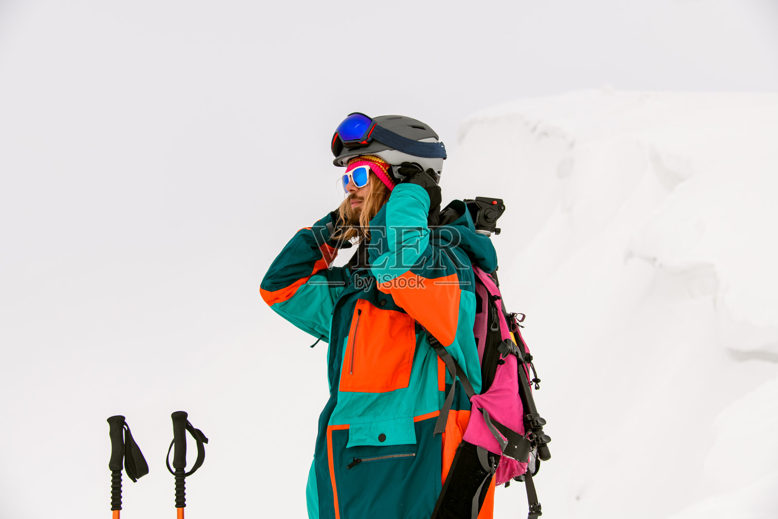 男子滑雪者在雪的背景下穿着鲜艳的彩色滑雪服和太阳镜照片摄影图片