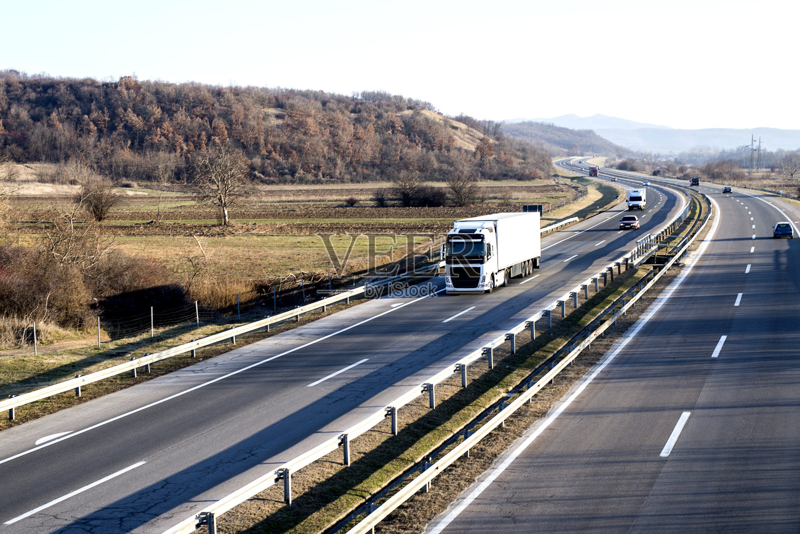 在乡村公路上排成一行的大篷车或卡车车队。照片摄影图片