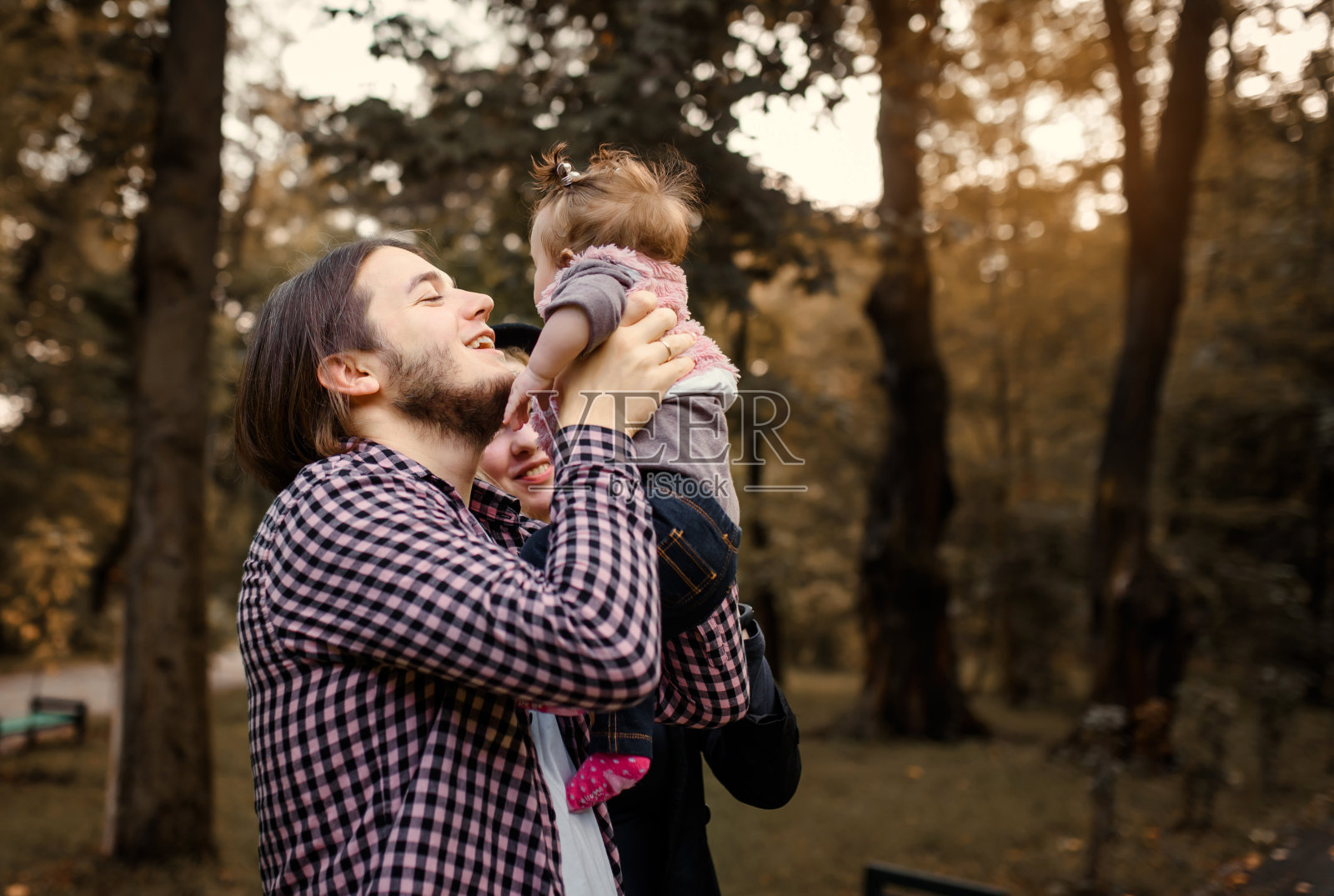 年轻漂亮的妈妈手里抱着孩子，爸爸在她身边。照片摄影图片