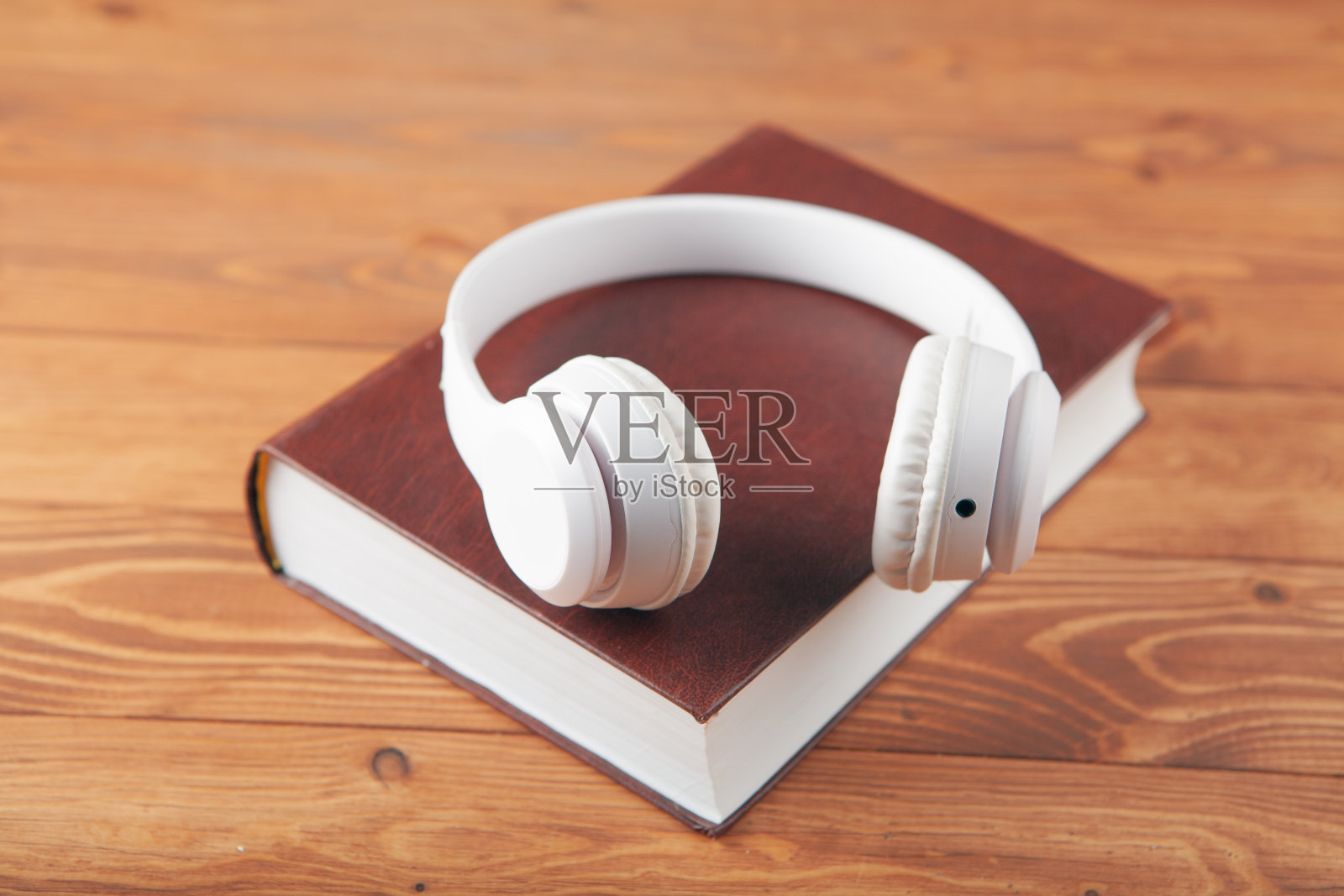 白色耳机在书上，还有放大镜照片摄影图片