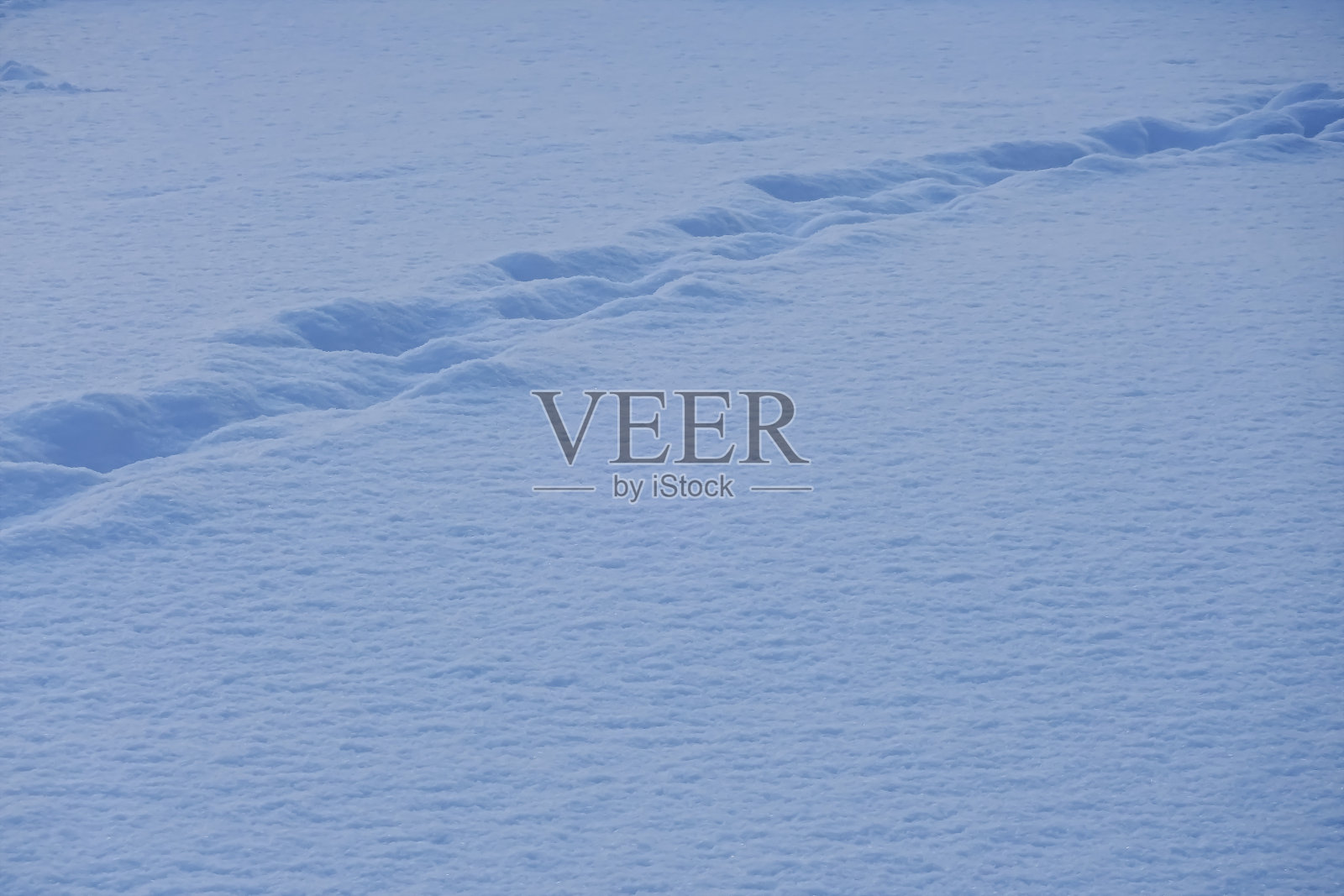 近距离拍摄，全帧白色，浅蓝色雪纹理与步骤在冬天的时间。背景或背景照片摄影图片