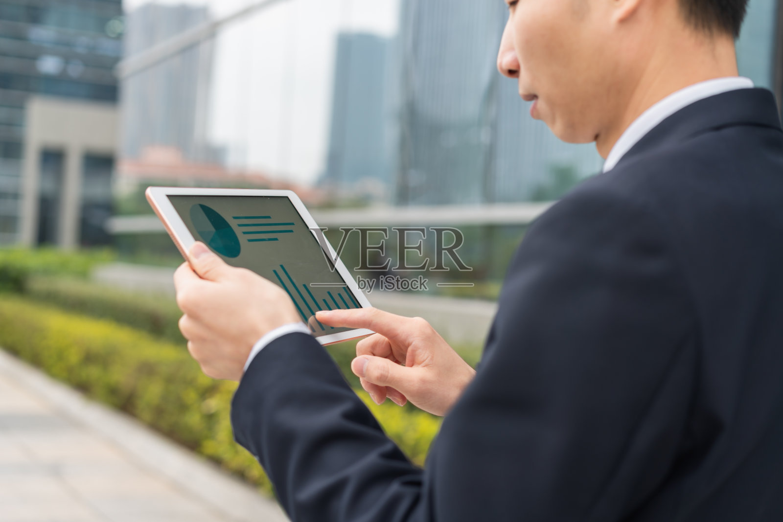 一名亚洲男子正在使用智能平板电脑照片摄影图片