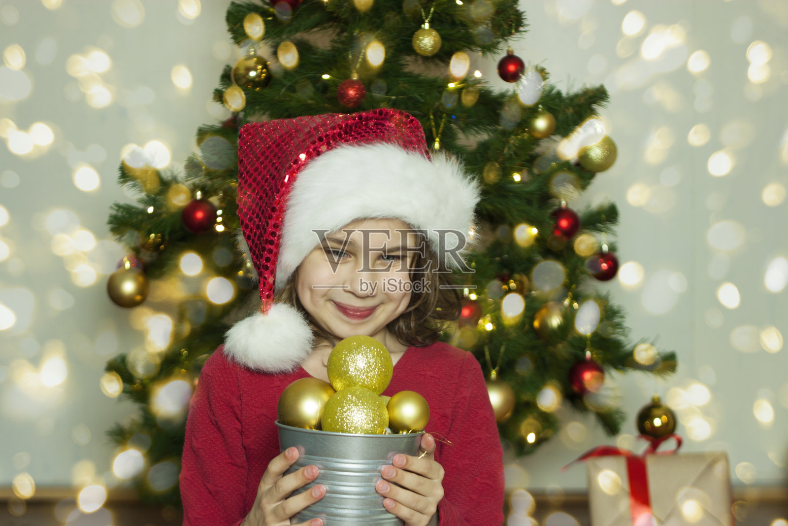 一个拿着圣诞玩具的女孩的肖像。照片摄影图片