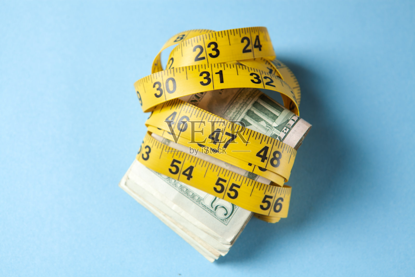 现金包裹在黄色卷尺里照片摄影图片