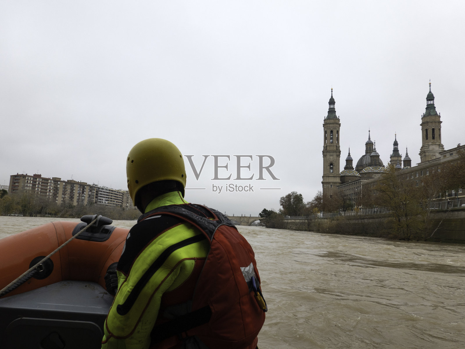 救援人员驾驶着船沿着城市旁边的河航行照片摄影图片