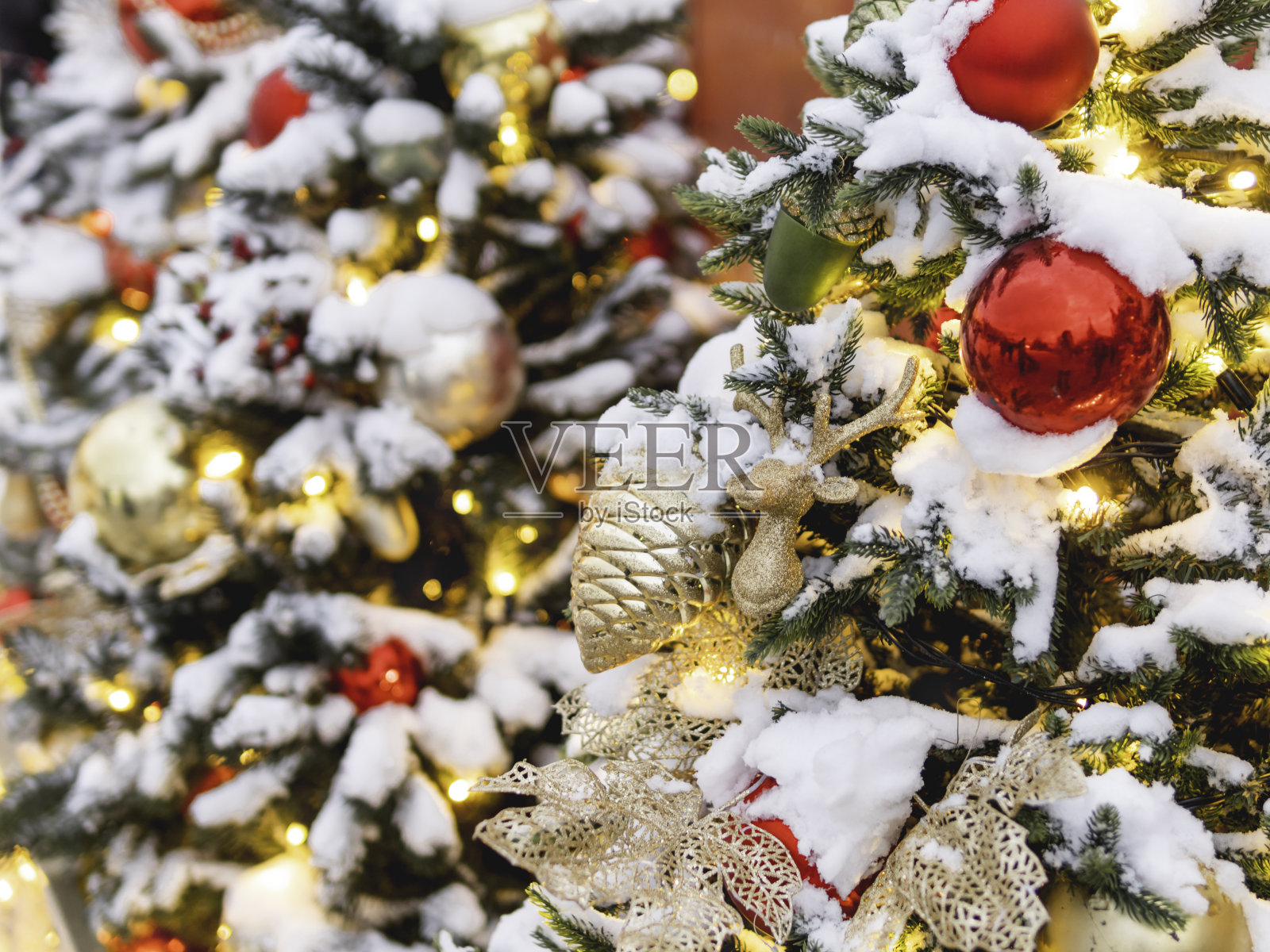 圣诞树上装饰着五颜六色的户外装饰品。圣诞树上装饰着灯泡和金色的松果，庆祝新年。照片摄影图片