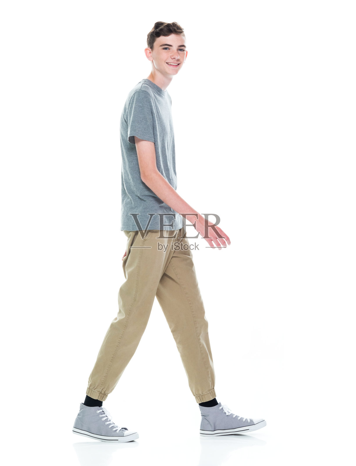 白人少年走在白人背景前面照片摄影图片