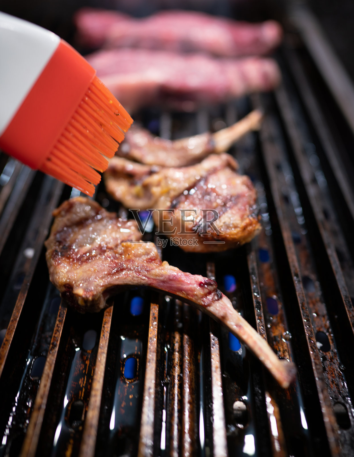 把羊排刷在烤肉上照片摄影图片