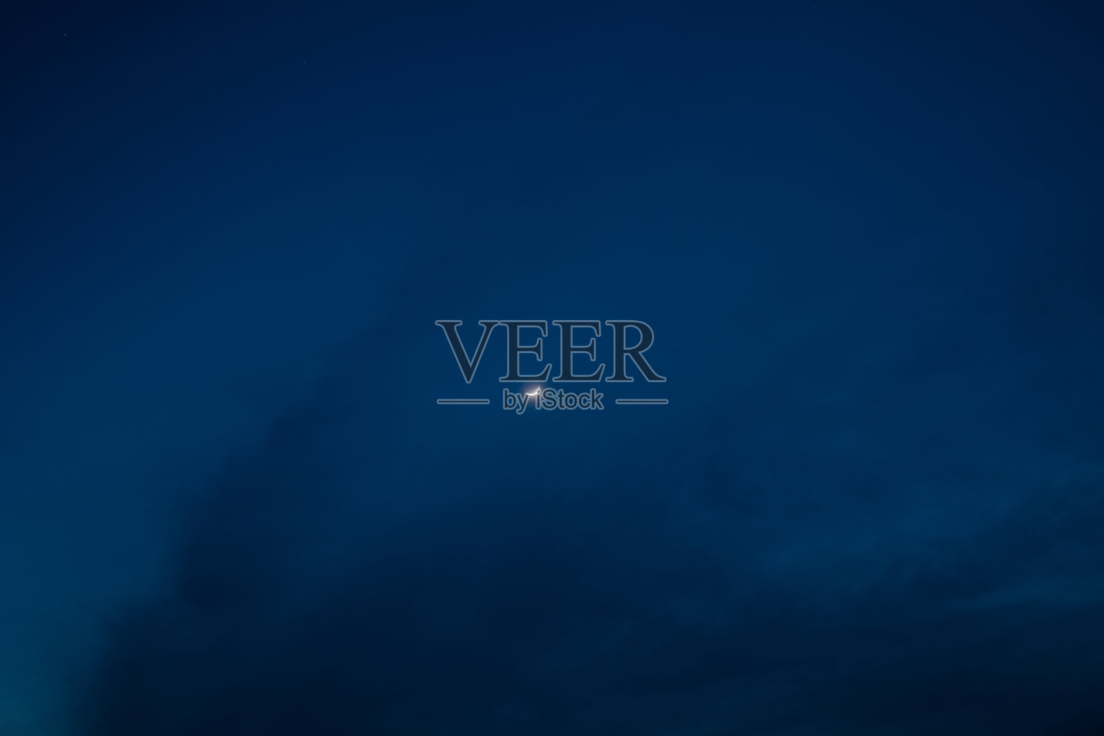 在美丽的深蓝色天空中出现了一轮月牙照片摄影图片