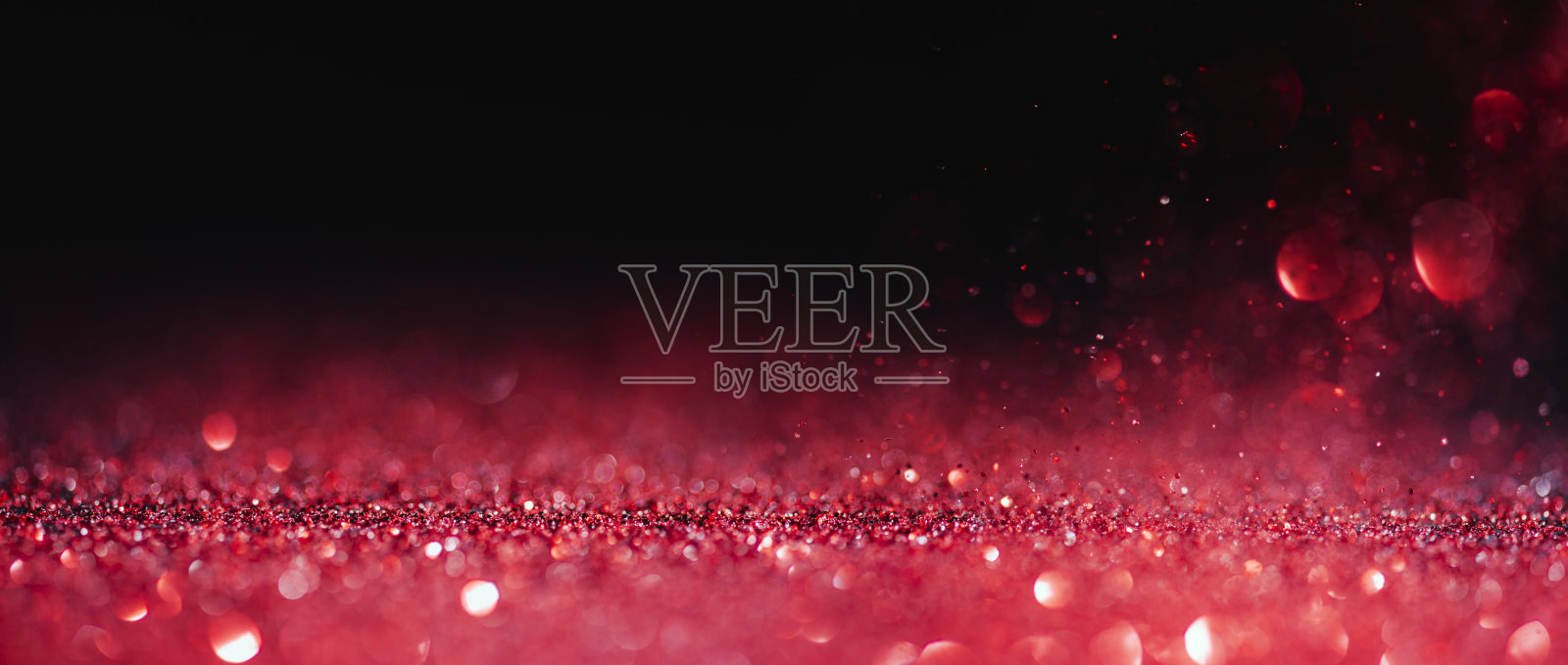 抽象模糊红色闪光在黑色背景。情人节贺卡，圣诞节贺卡和婚礼贺卡。爱散景闪耀五彩纸屑纹理布局。照片摄影图片