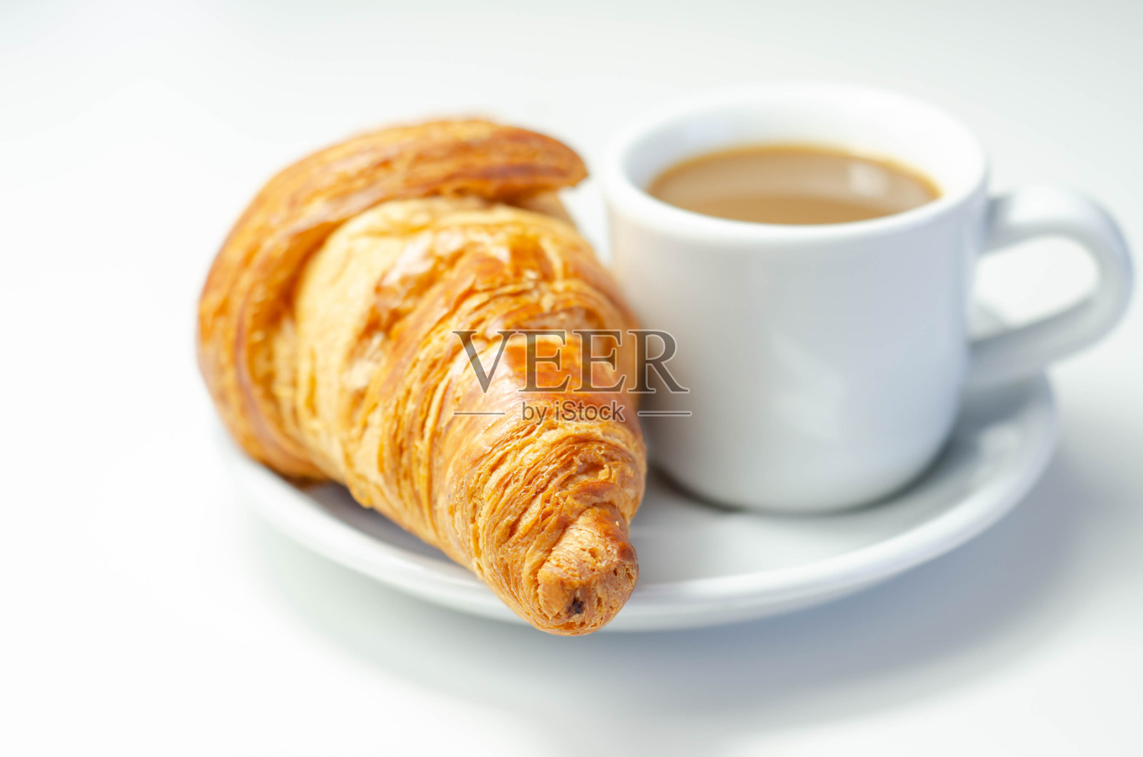 牛角面包和巧克力放在盘子里，咖啡放在杯子里照片摄影图片