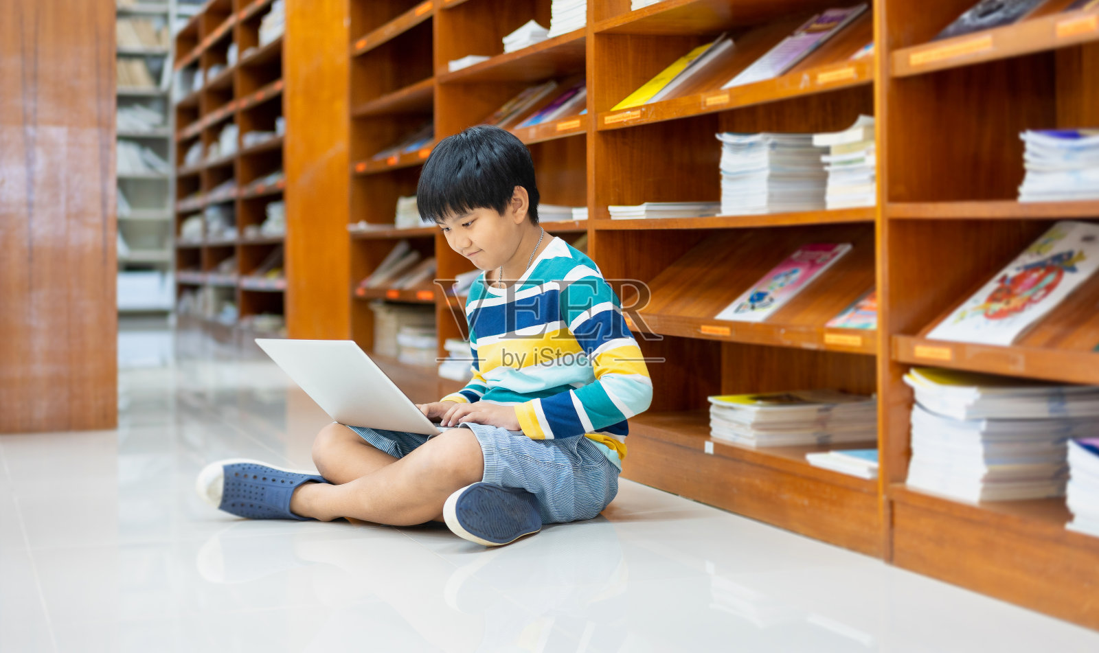 亚洲学生的肖像在休闲衬衫与笔记本电脑在公共图书馆，学校和学习的计算机概念照片摄影图片