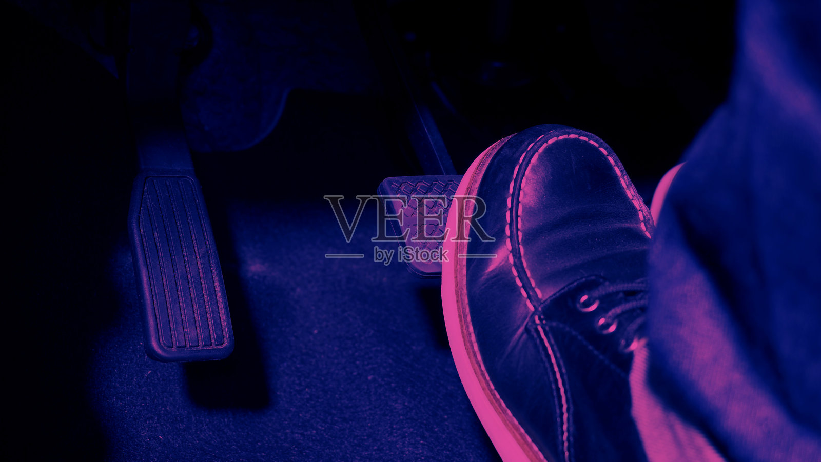 汽车的油门和刹车踏板。紧踩汽车的脚踏板向前行驶。司机通过推动汽车的油门踏板来驾驶汽车。脚踏板在车内。照片摄影图片