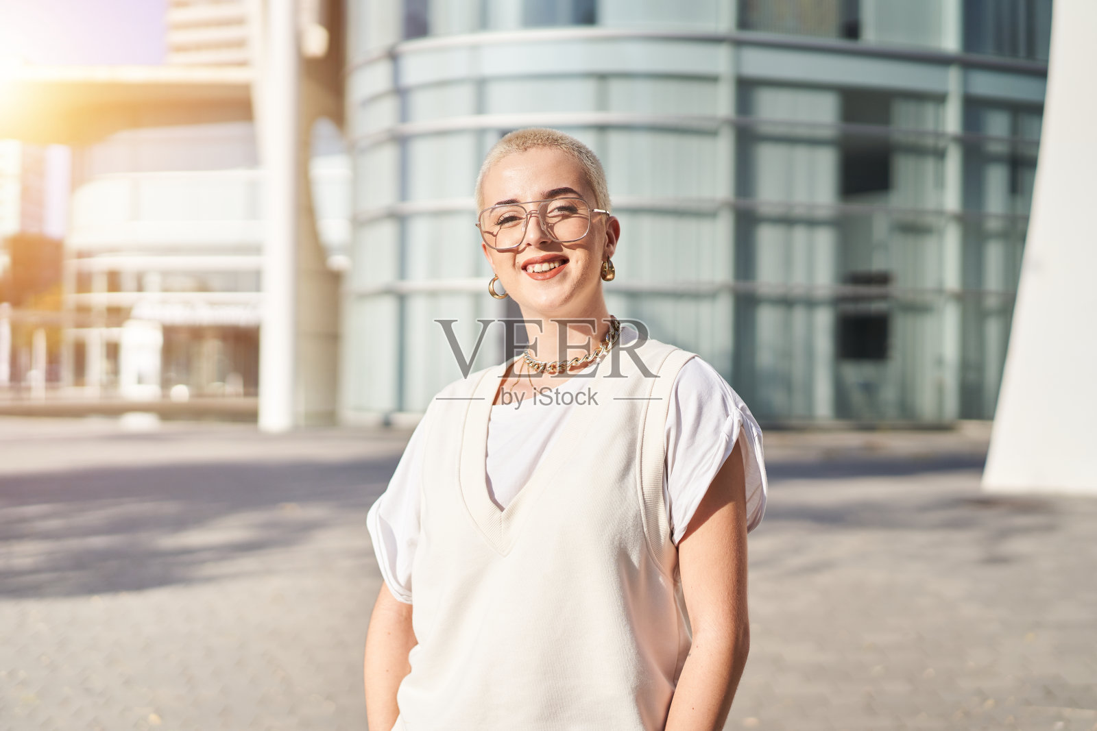 快乐的剃了头发的女人在户外看着相机照片摄影图片