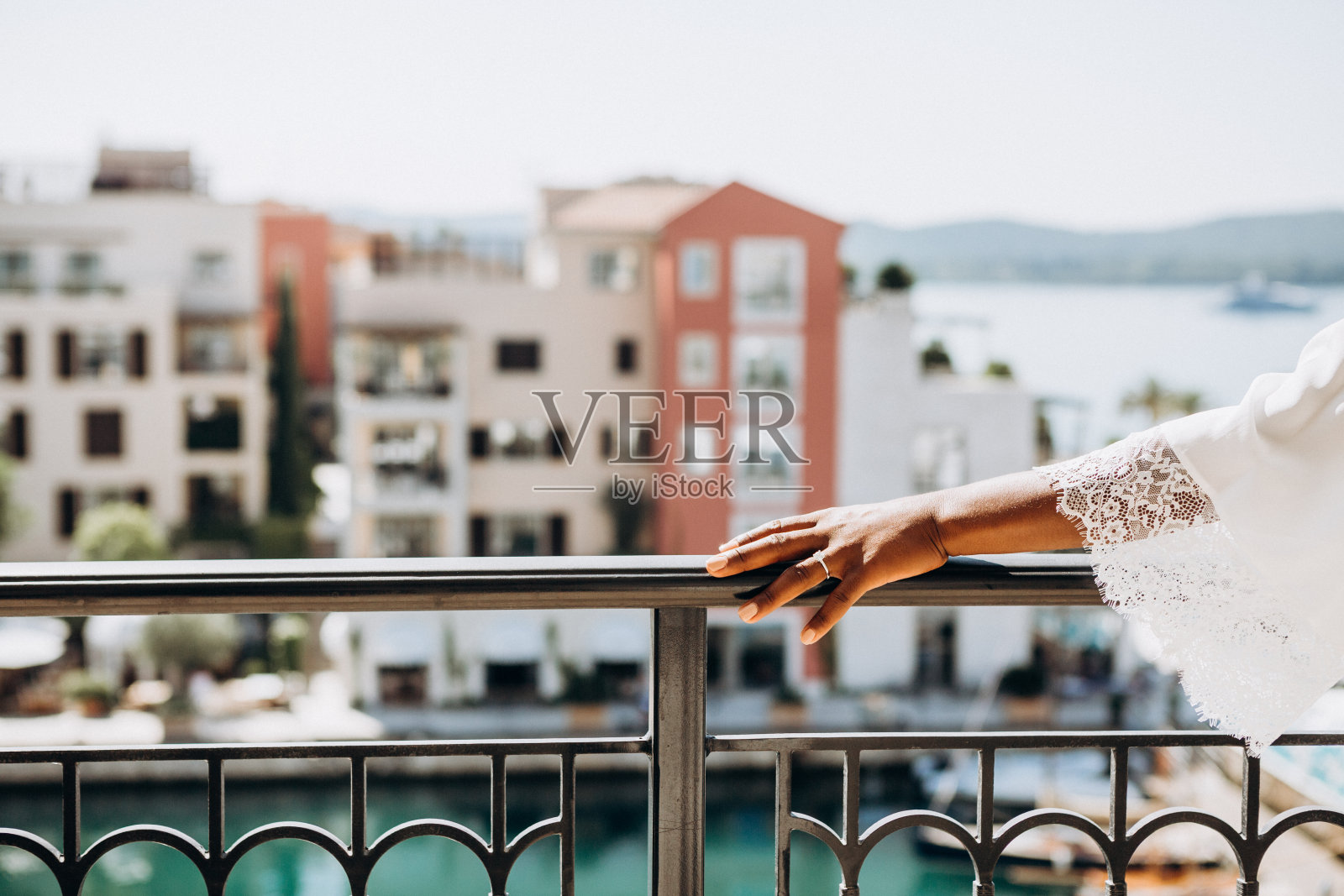 一枚镶有钻石的戒指放在新娘手上俯瞰大海的露台上照片摄影图片