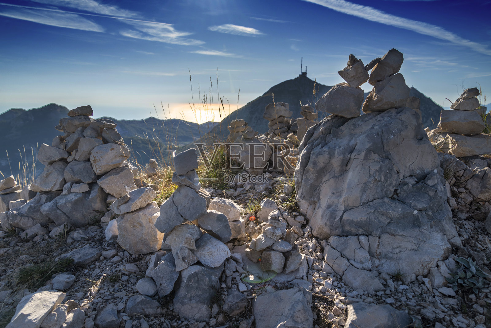 东欧黑山，日落时洛岑山顶上的石堆。照片摄影图片