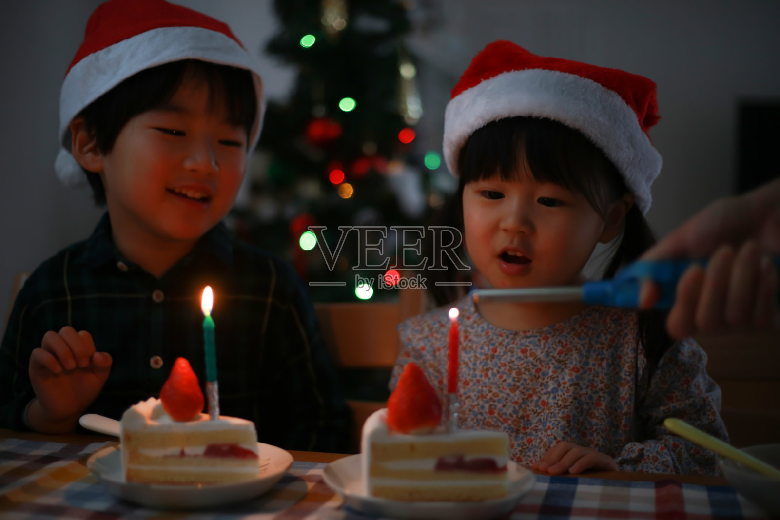 孩子们吹熄蛋糕上的蜡烛照片摄影图片