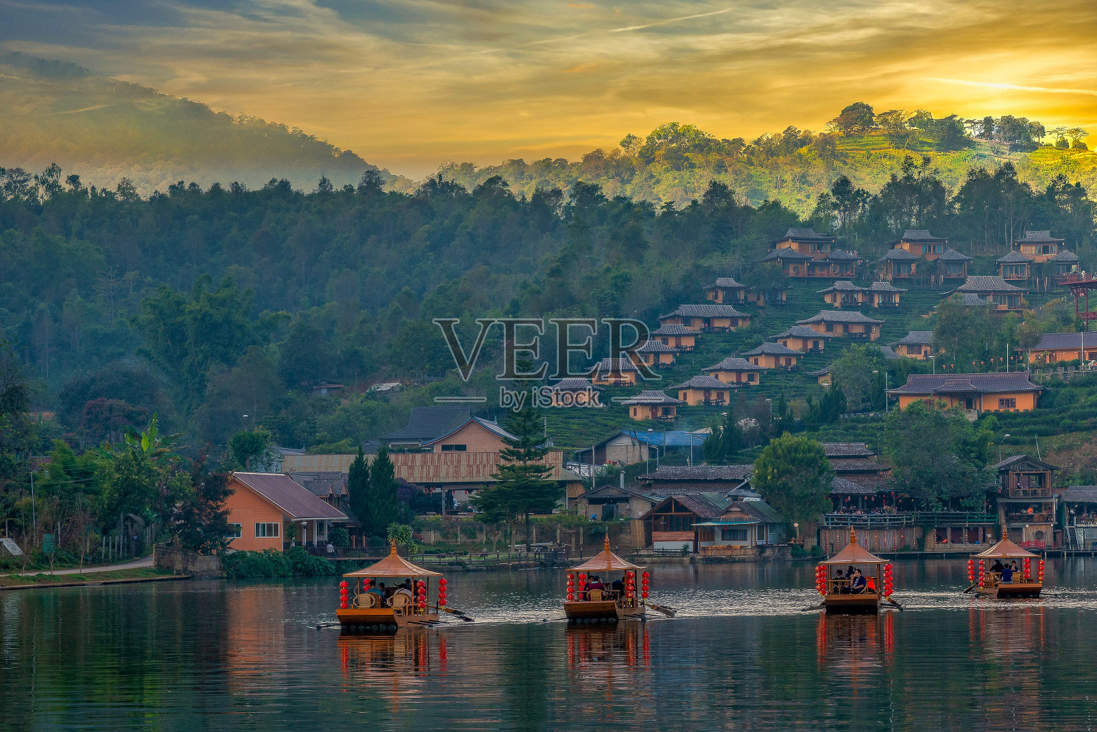 前景中的船只和班乐泰山上的日落照片摄影图片
