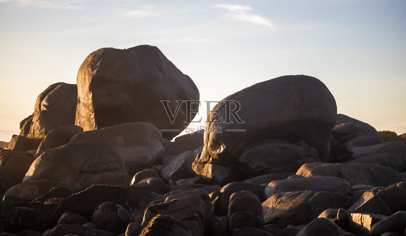 日落时分，南非雅各布拜伊海滩上巨石的金色剪影照片摄影图片