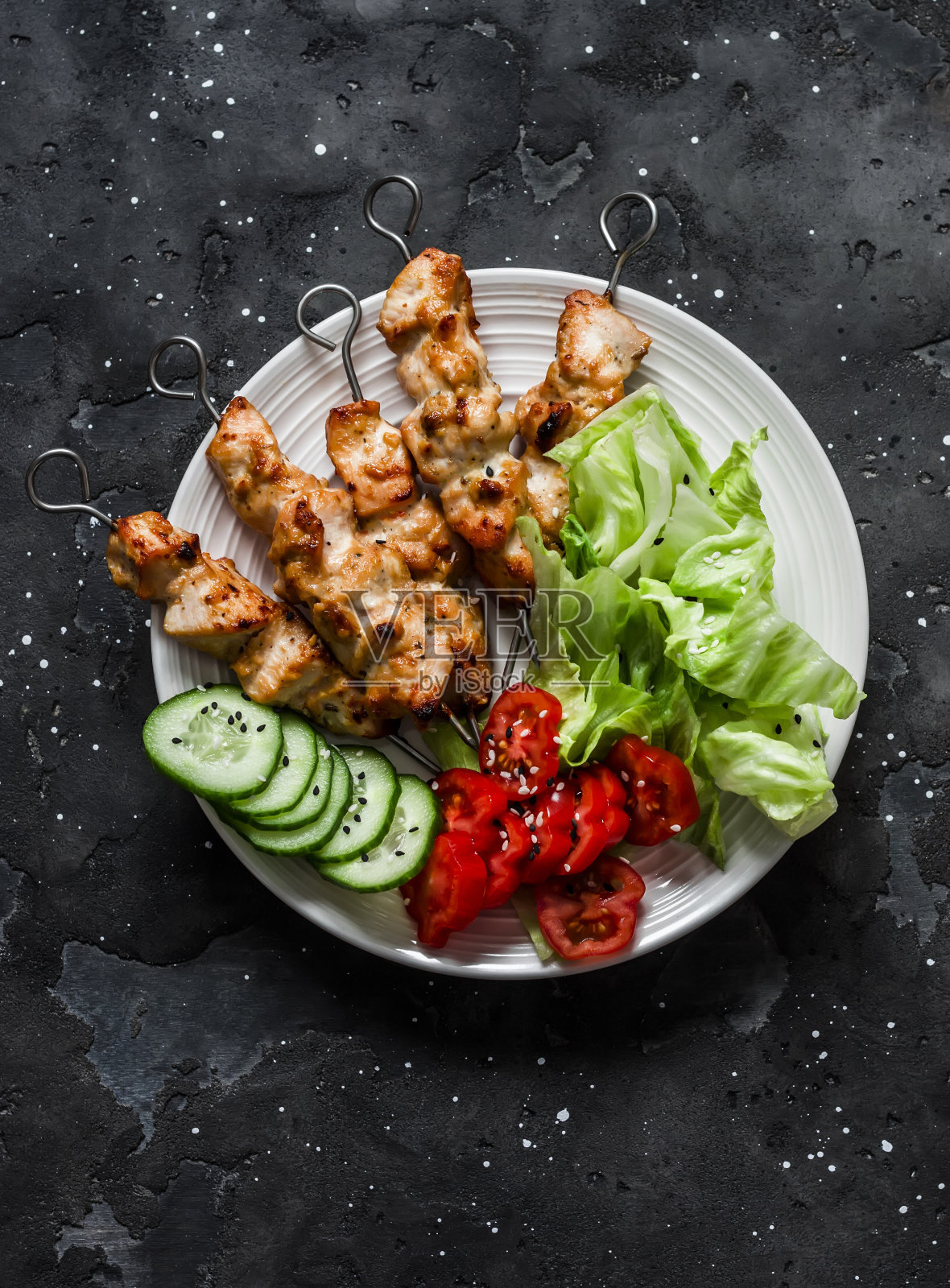 花生酱，酸奶和酱油鸡肉沙茶串与新鲜蔬菜沙拉在黑暗的背景，俯视图照片摄影图片