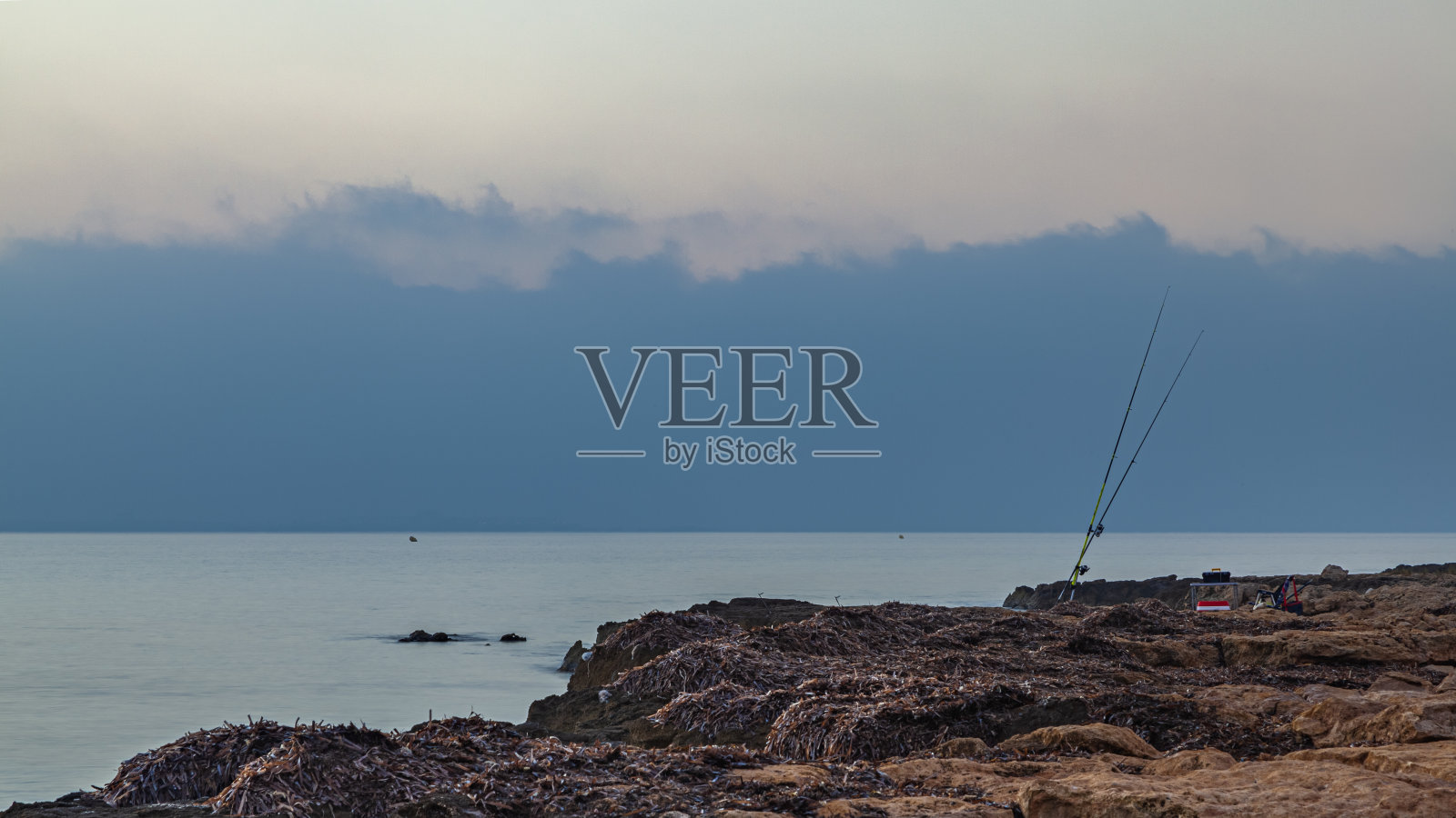 海边的两根钓鱼竿照片摄影图片