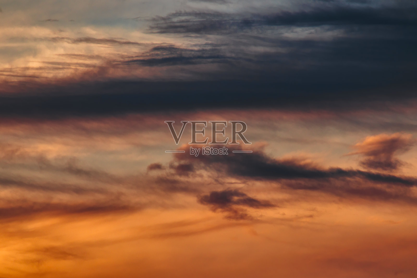 在薄雾笼罩的天空下，漂浮着一簇簇的阴影。照片摄影图片