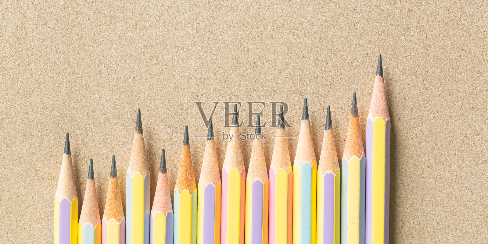 木制铅笔在棕色的纸上，几支铅笔在棕色的纸上，俯视木制棕色的铅笔放在棕色的纸上为背景照片摄影图片