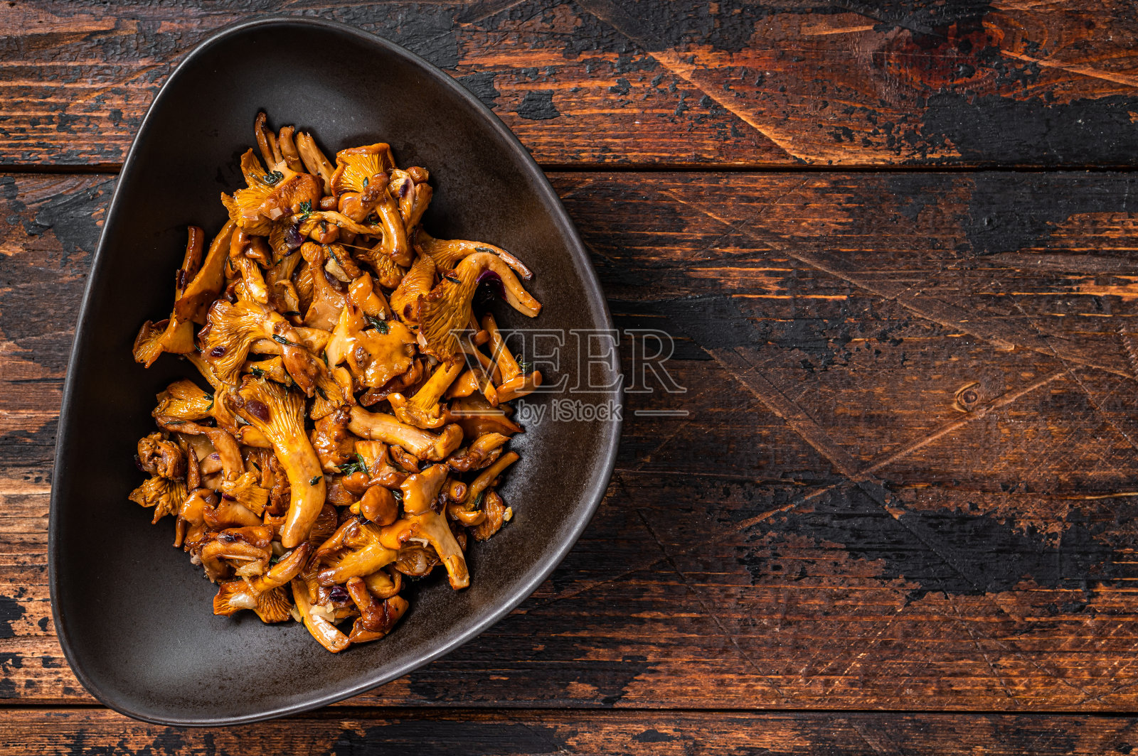 森林鸡油菌炒香草。木制背景。前视图。本空间照片摄影图片