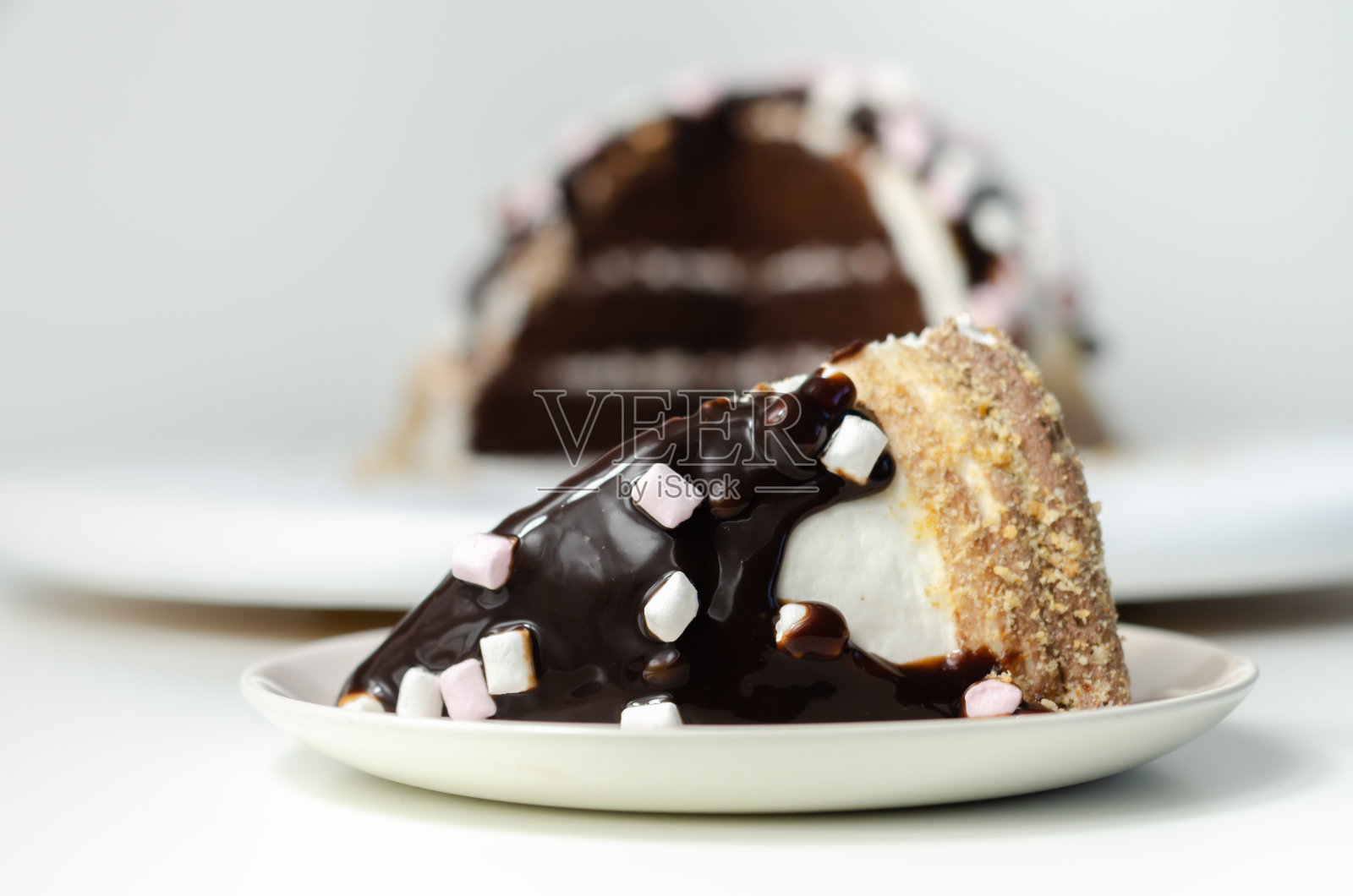 巧克力海绵蛋糕，外裹棉花糖味糖霜，巧克力味糖霜，用巧克力酱和棉花糖装饰消化屑照片摄影图片