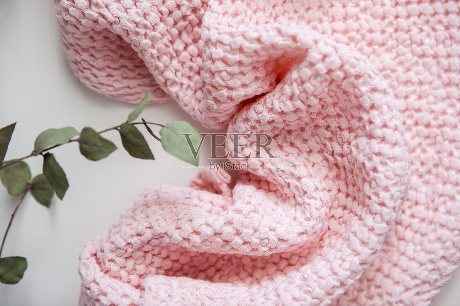 粉红色的毛巾，白色的背景，桉树的干树枝照片摄影图片