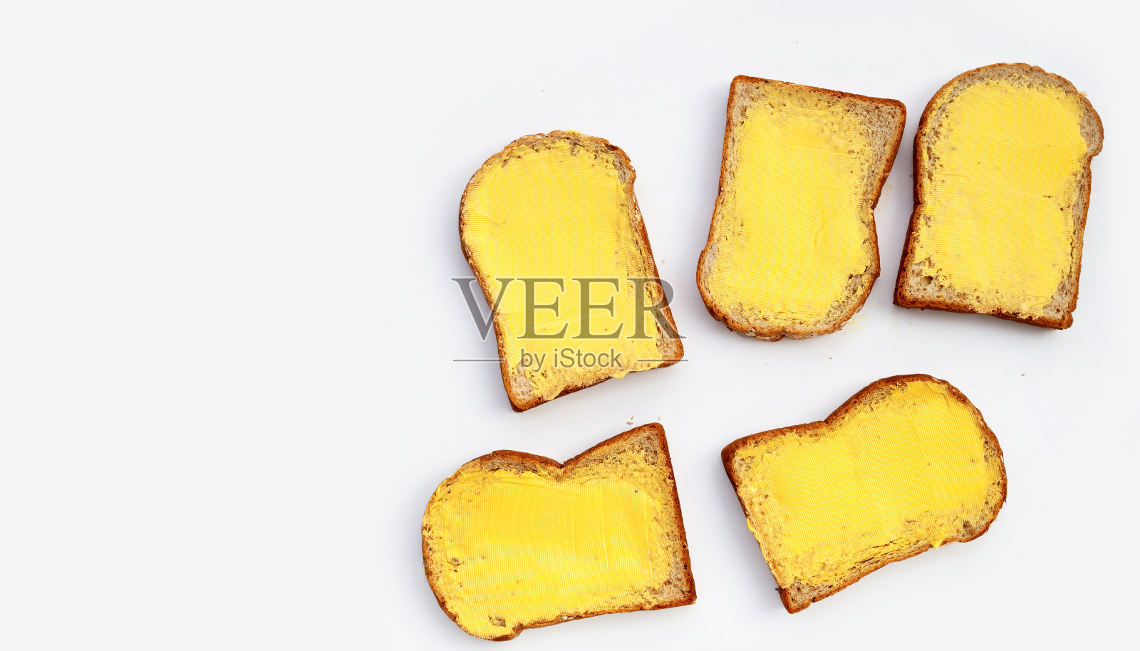 白色背景上涂黄油的面包片。照片摄影图片