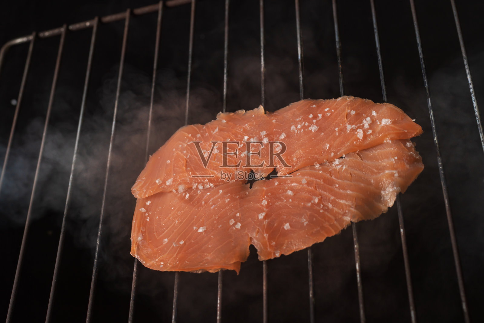 烤架上的烟熏三文鱼片。照片摄影图片