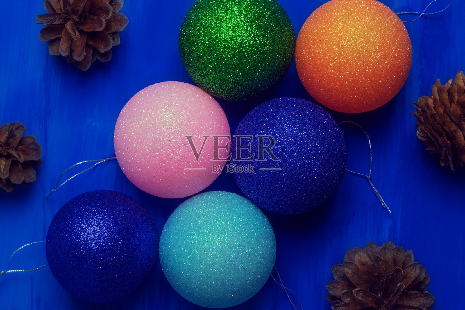 六个不同颜色的圣诞树玩具躺在蓝色的背景上照片摄影图片