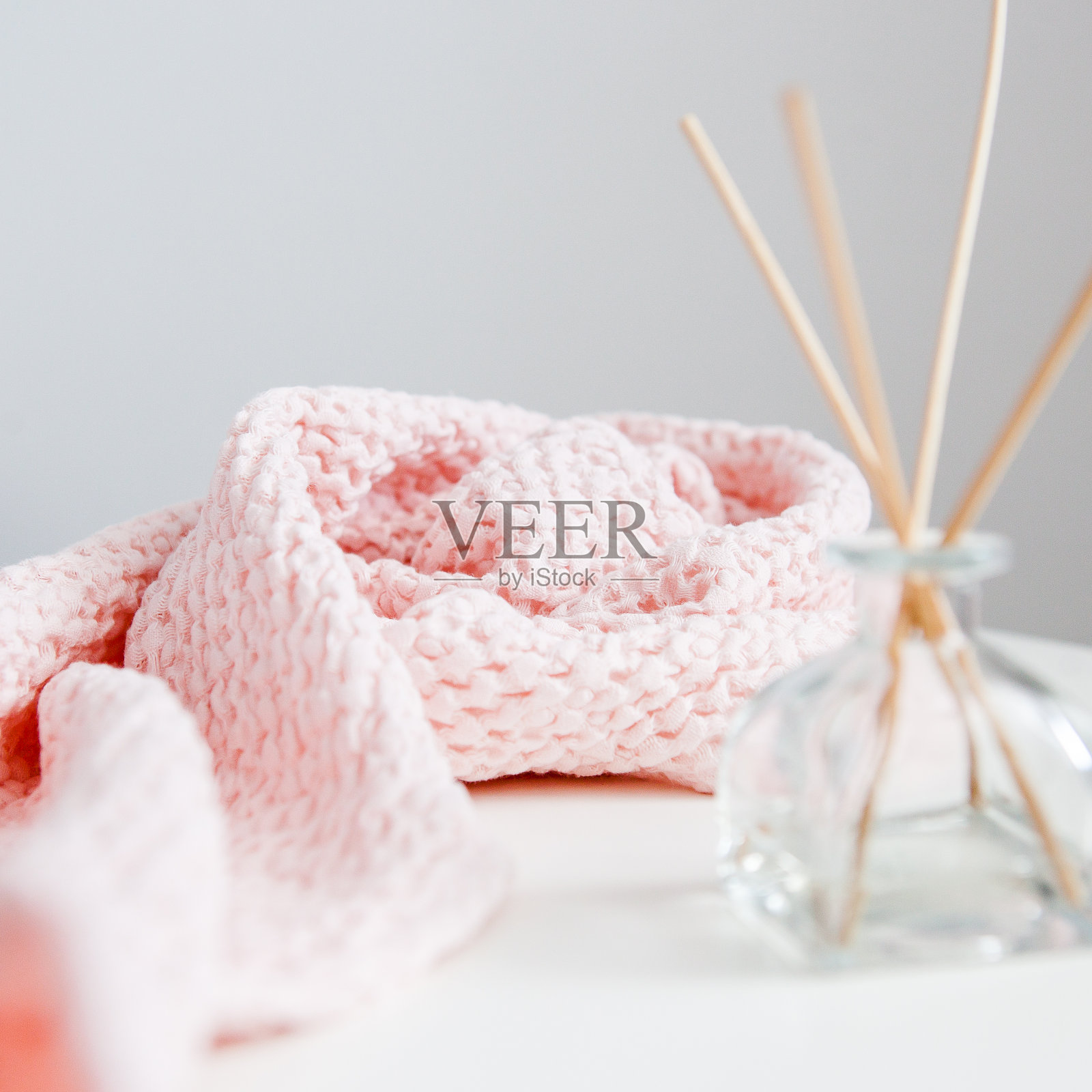 芳香扩散器与棍棒白色背景与粉红色软毛巾照片摄影图片