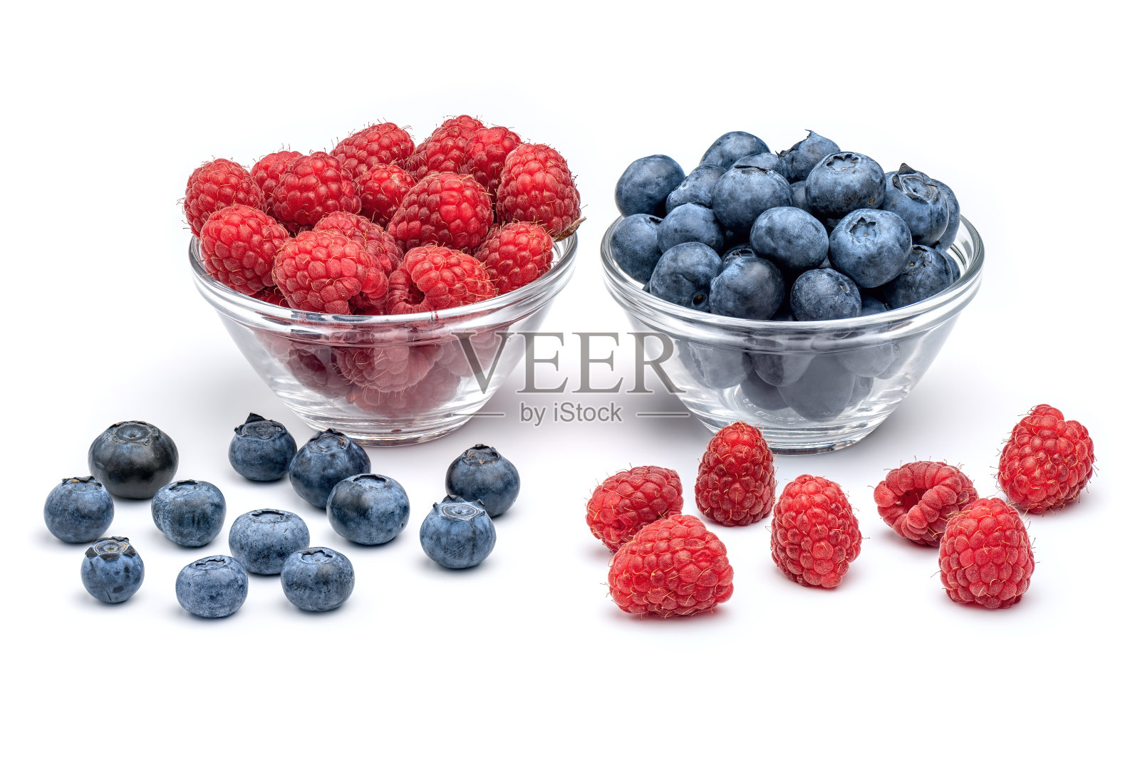 新鲜的树莓和蓝莓放在玻璃碗里，白色背景。照片摄影图片