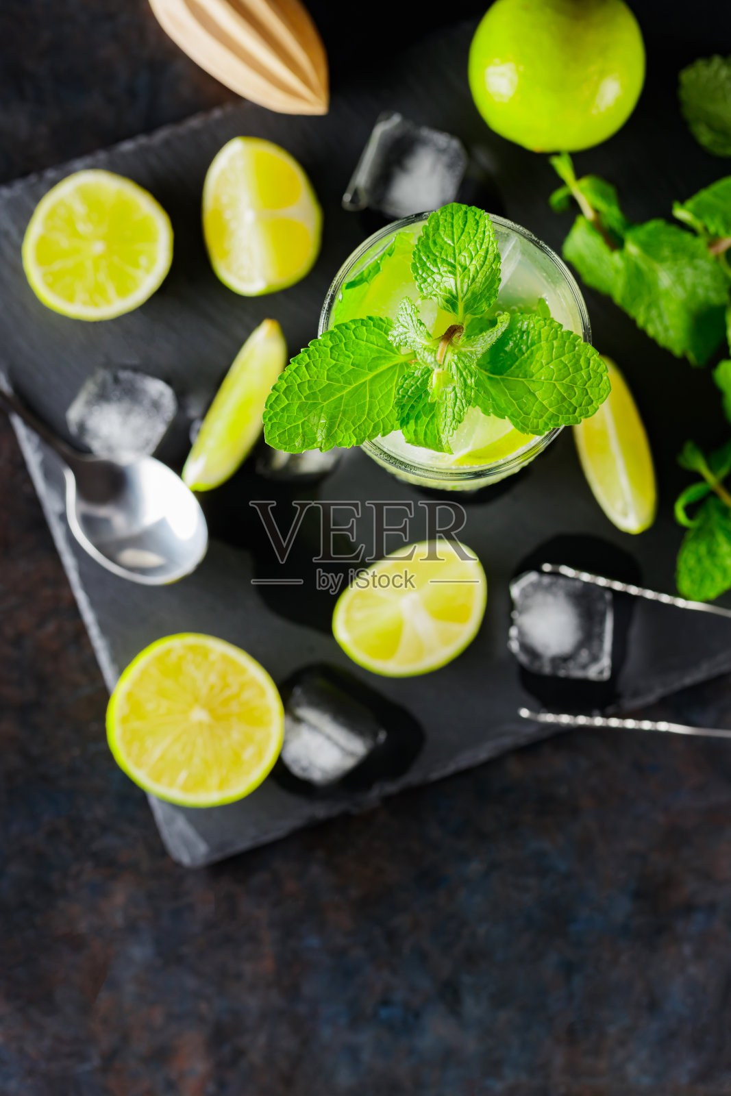 黑色背景上的莫吉托鸡尾酒和配料。清爽的鸡尾酒莫吉托在石板上。夏季鸡尾酒概念与柠檬和薄荷。俯视图照片摄影图片