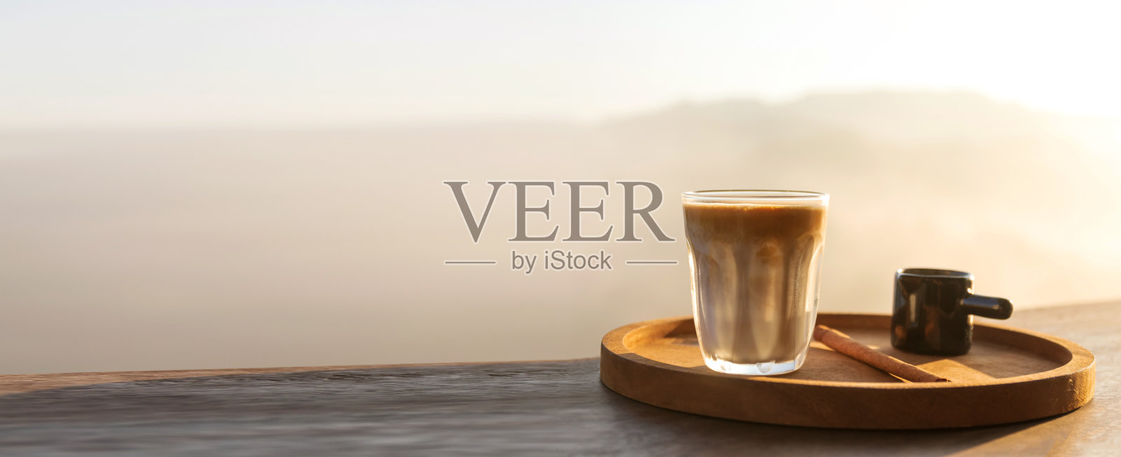 大自然中的日出咖啡。脏咖啡在木桌上与山雾在阴影的日出背景。早上好。16：9照片摄影图片