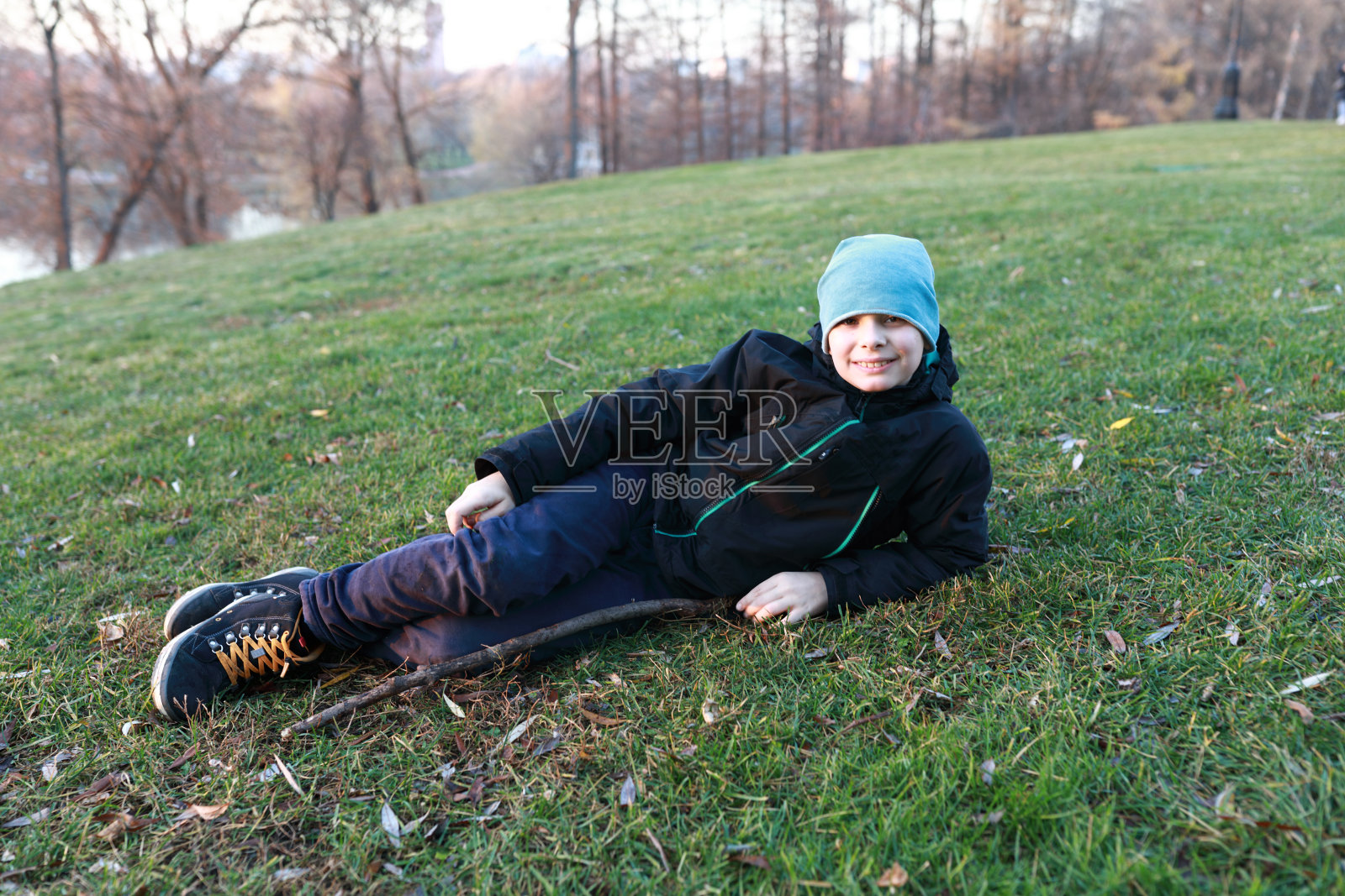 秋天，孩子躺在草坪上照片摄影图片