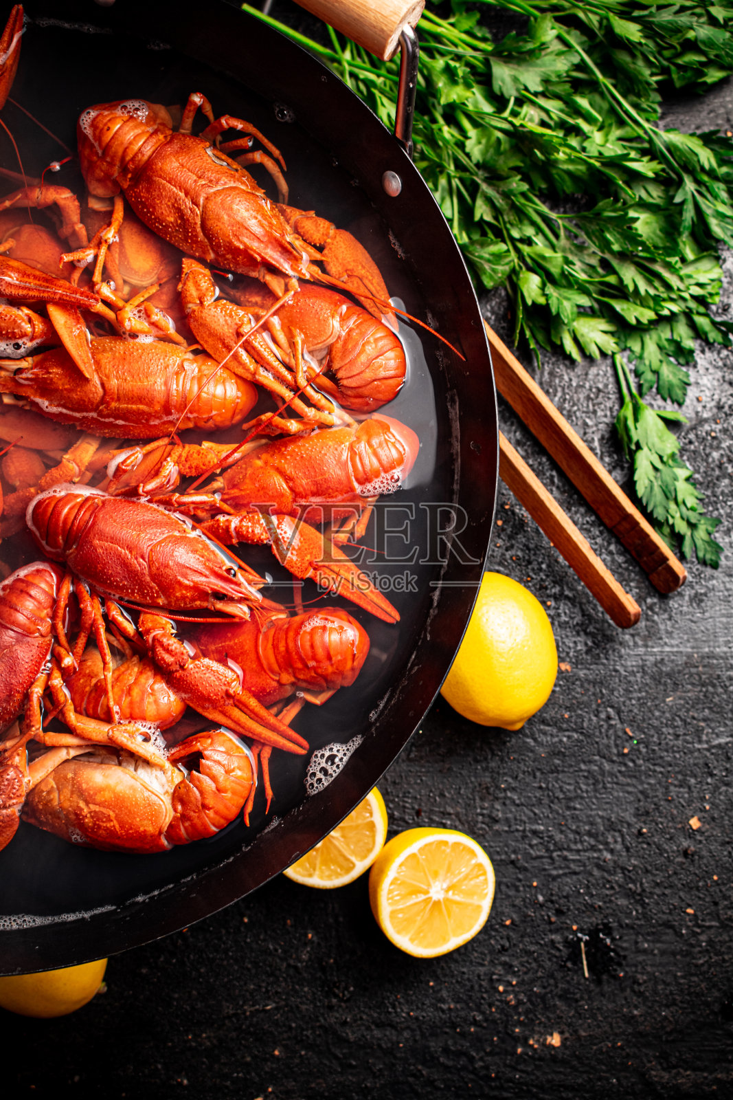 用香菜和柠檬煮小龙虾。照片摄影图片