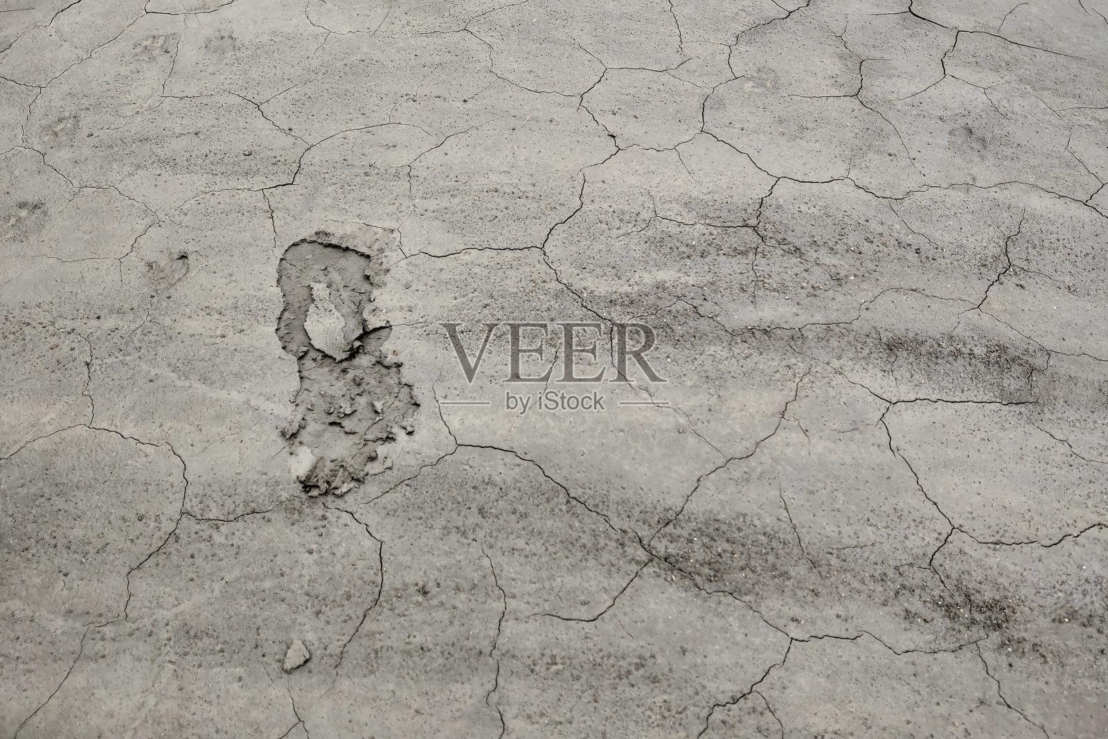 干燥开裂的泥土表面。有裂缝的干粘土的质地。37、人类的足迹在干燥的土壤上留下了断层。照片摄影图片