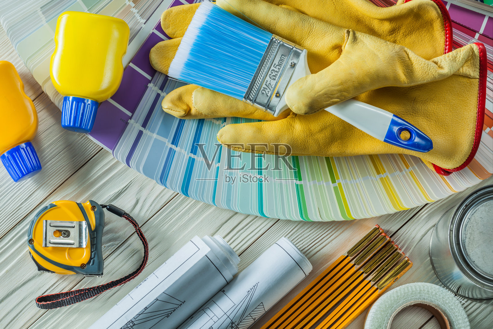 在白色的木板上，用任何其他施工工具在工作手套上刷漆照片摄影图片