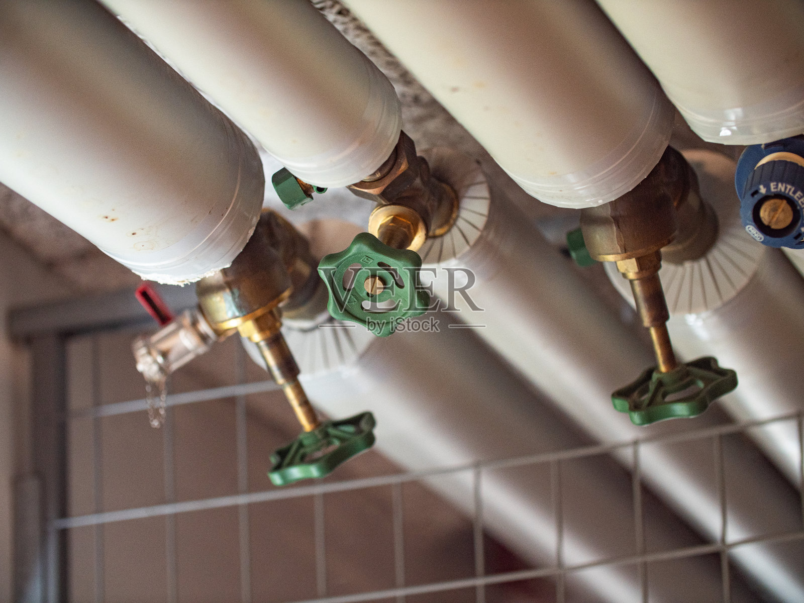 墙壁上的燃气和水的绝缘管道用绿色阀门照片摄影图片