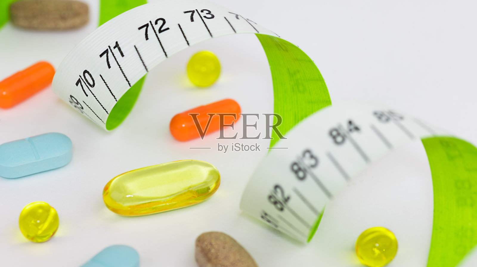 卷尺和几粒药丸。照片摄影图片