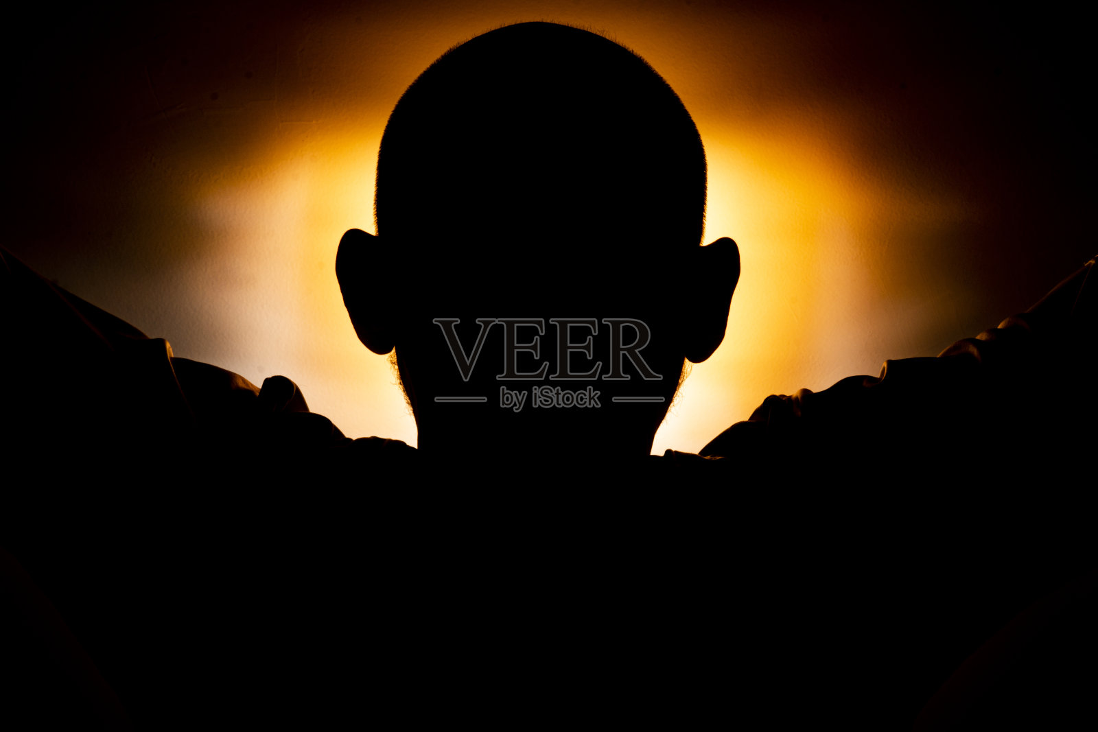 橙色背景下男子头部的特写剪影。照片摄影图片