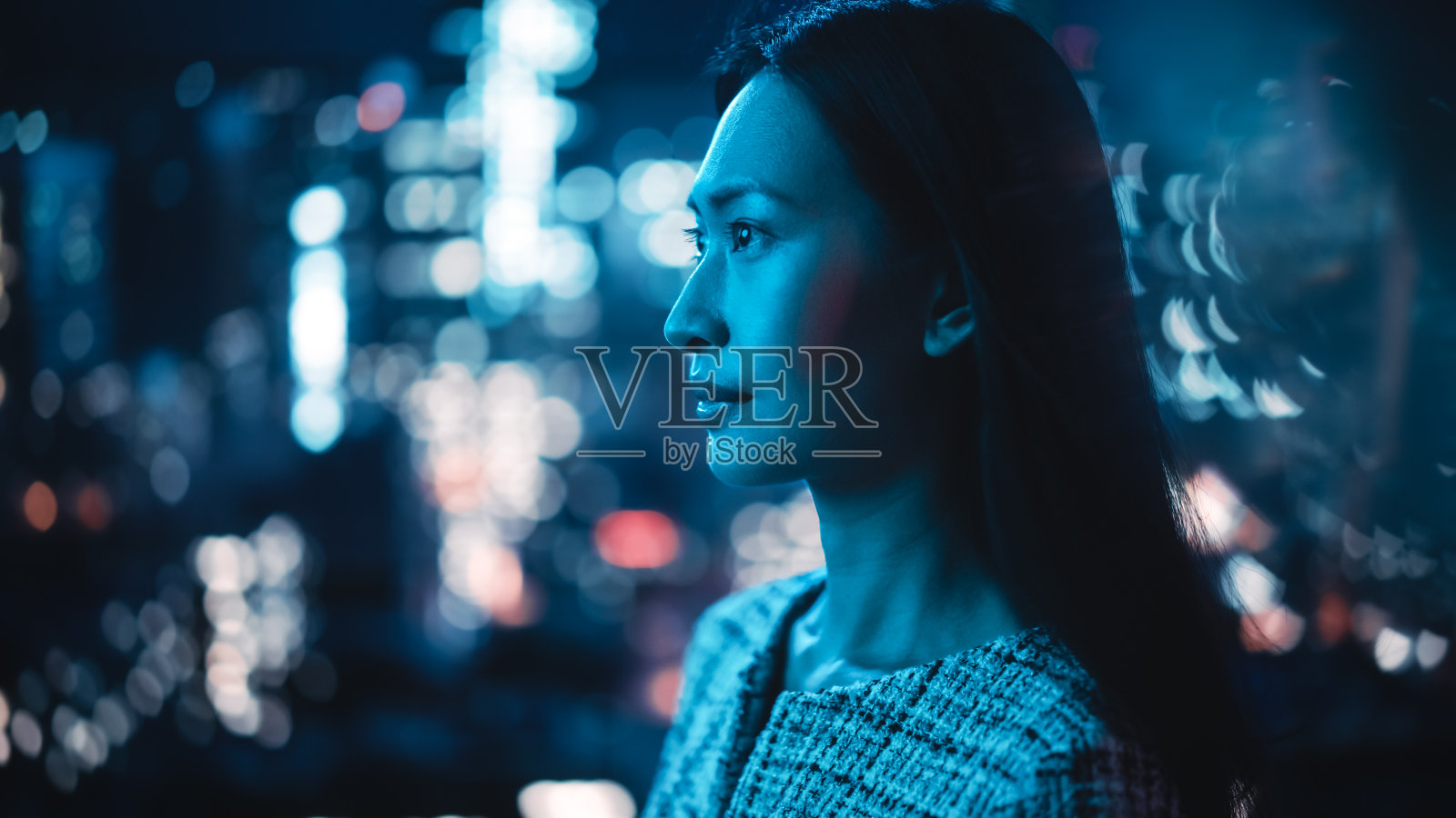 美丽的亚洲女性肖像站在城市街道霓虹灯深夜。真实自信的成年女性在市中心商业街的夜晚对着镜头摆姿势微笑。照片摄影图片