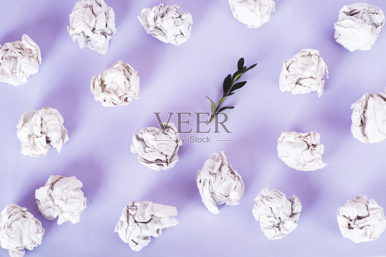 头顶的照片中，皱巴巴的纸整齐地排列着，绿色的小树枝夹杂在非常幽雅的背景中。“零浪费”的概念照片摄影图片