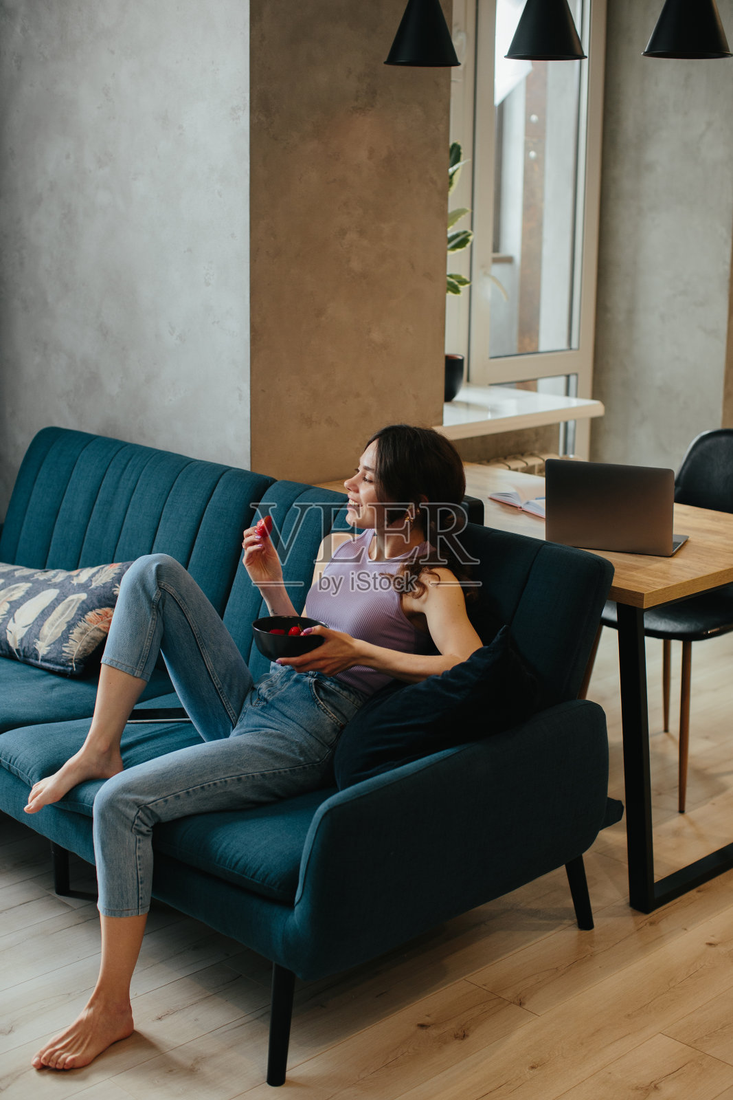 小女孩坐在沙发上吃着草莓照片摄影图片