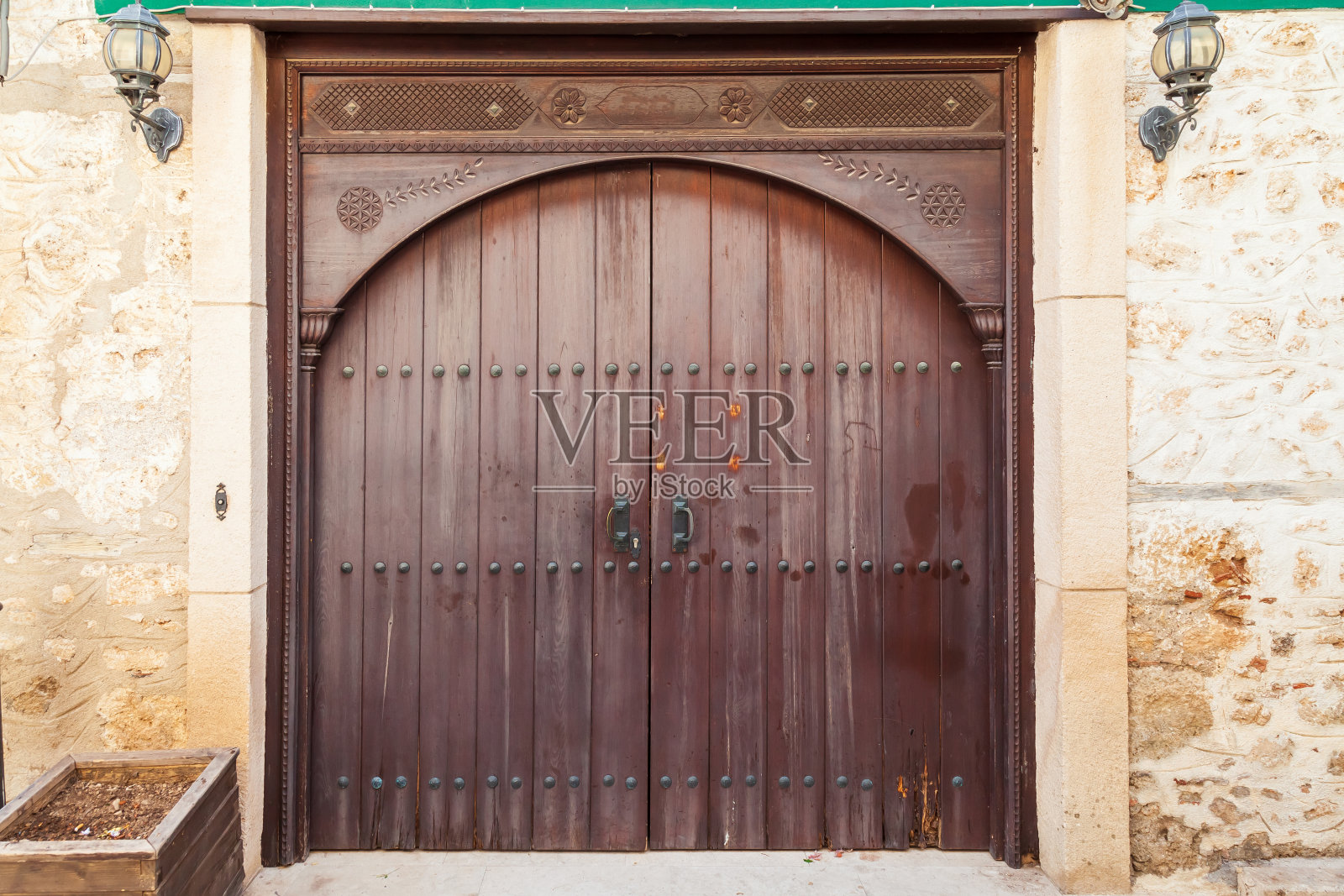 建筑立面和古色古香木门的特写。有纹理的石砖和一扇古老的木门照片摄影图片